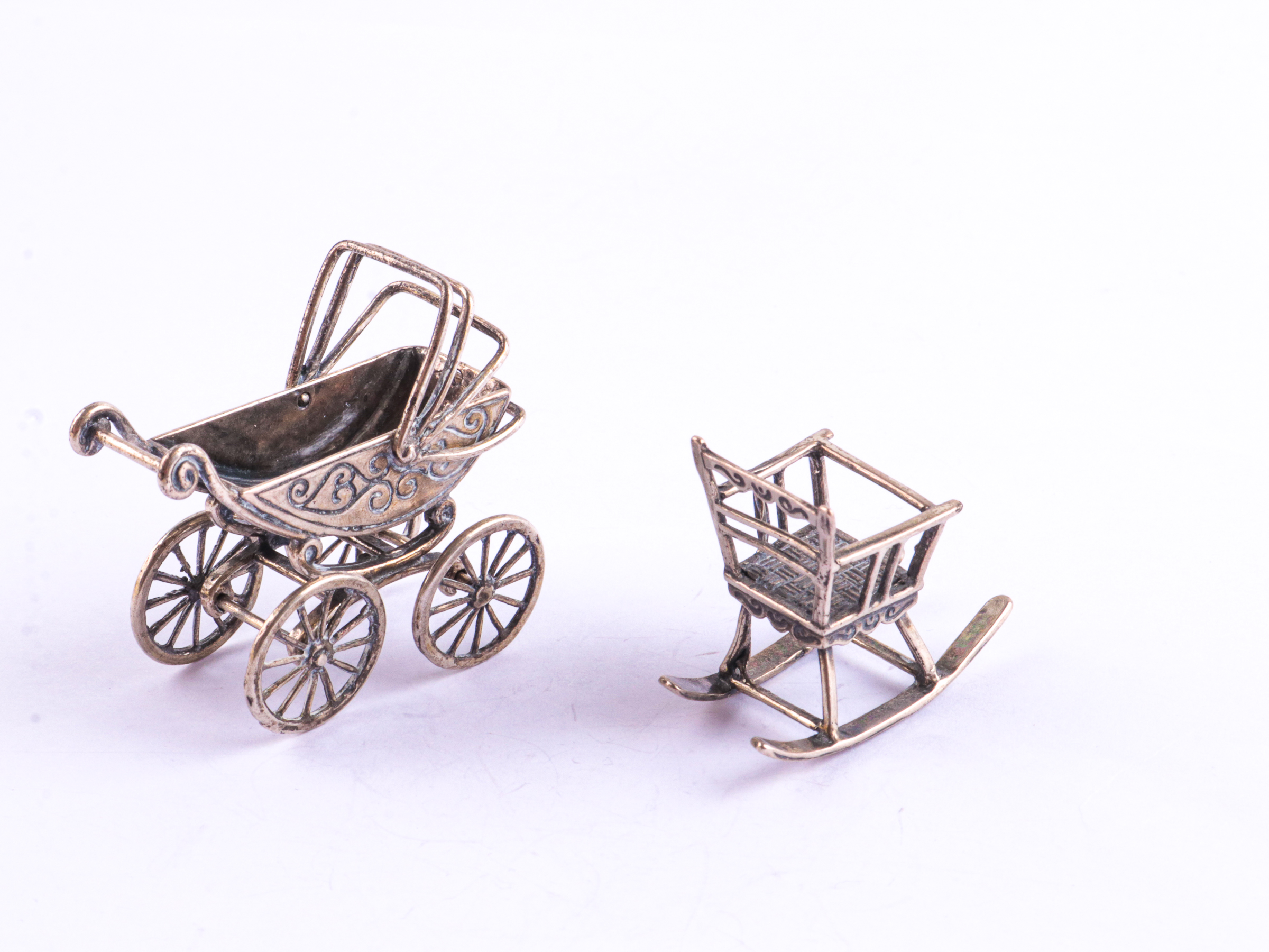 Zilveren miniaturen wandelwagen en schommelstoel
